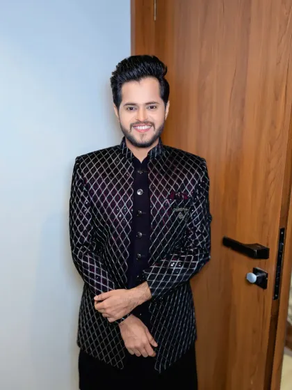 A full look at this modern groom's outfit. The combination of a textured jacket and clean grooming is a winning formula for any pre-wedding event.