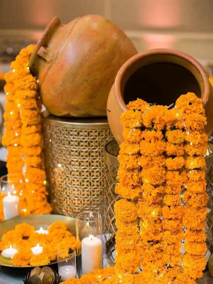 For festive occasions like Diwali, I create stunning decor arrangements. Here, I've used old terracotta pots to create a "waterfall" of marigold flowers and fairy lights, surrounded by the warm glow of candles.