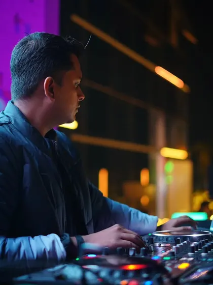A candid shot of me focused on my laptop, selecting the next track during an outdoor rooftop set.