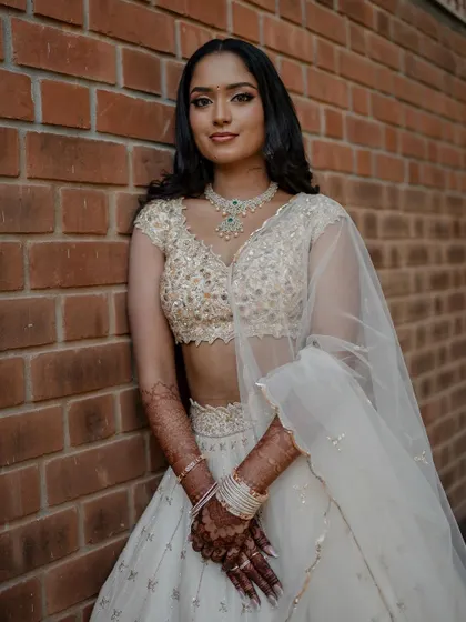A stunning bride in a white lehenga, exuding grace and elegance. We use creative framing and lighting to capture a variety of beautiful portraits.