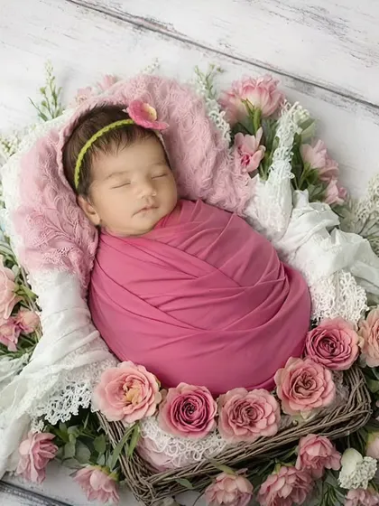 Surrounded by soft pink roses, this baby girl looks like a sleeping beauty. Floral themes are a wonderful way to add color and delicacy to a newborn session, and I always use high-quality, baby-safe props.