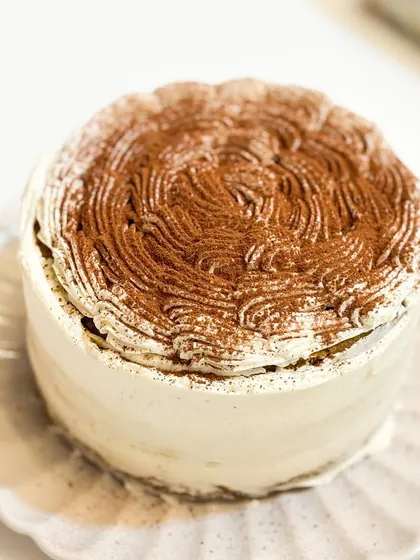 Lost in a world of gluten-free Tiramisu bliss. This cake is a coffee lover's dream, made with rich mascarpone and a dusting of cocoa.