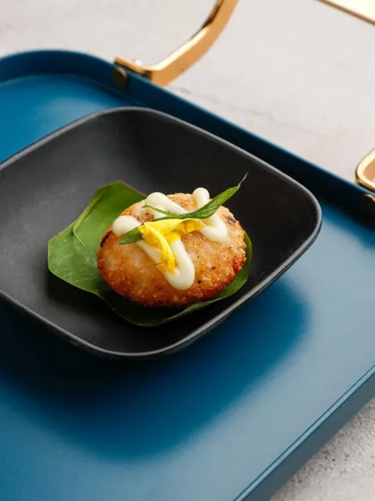 A beautifully composed shot of our Japanese rice balls. Placed in a modern black dish on a vibrant blue tray, this image highlights the care we put into both flavour and presentation.