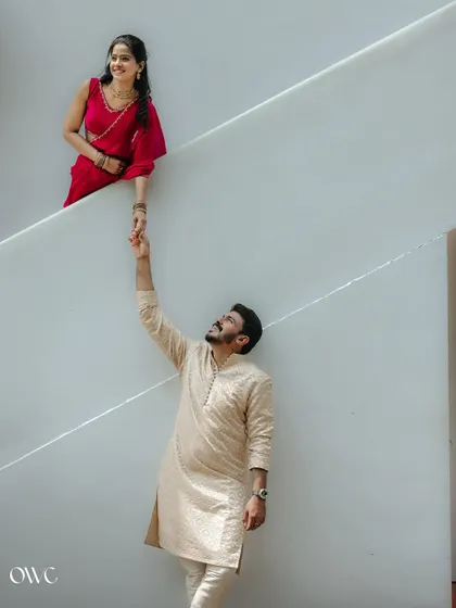 A romantic gesture as the groom-to-be reaches for his partner's hand across the diagonal of a staircase.