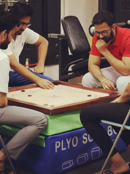 A wider view of our team enjoying a game of carrom in the clinic. We believe in creating a positive and fun work environment.