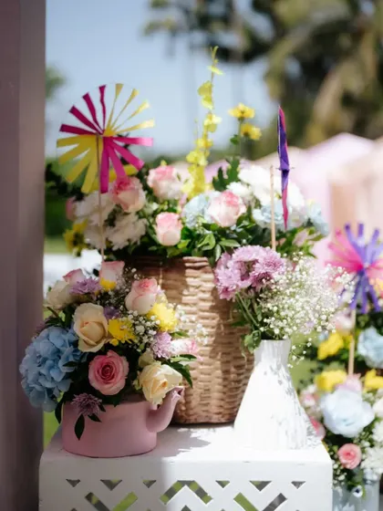 A beautiful floral centerpiece with a pinwheel, part of the whimsical decor for the 'Pastel Mela' Mehendi.