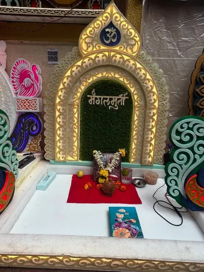 A beautiful, ready-made miniature mandir or 'makhar' for your idol. This ornate piece is lit from within and features intricate peacock designs, providing a divine throne for your deity.