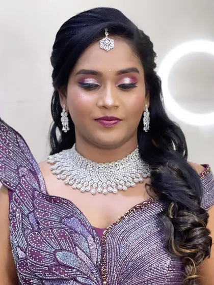A close-up of Anitha's unique reception makeup. The purple smokey eye and diamond jewelry are perfectly coordinated with her butterfly-inspired gown.
