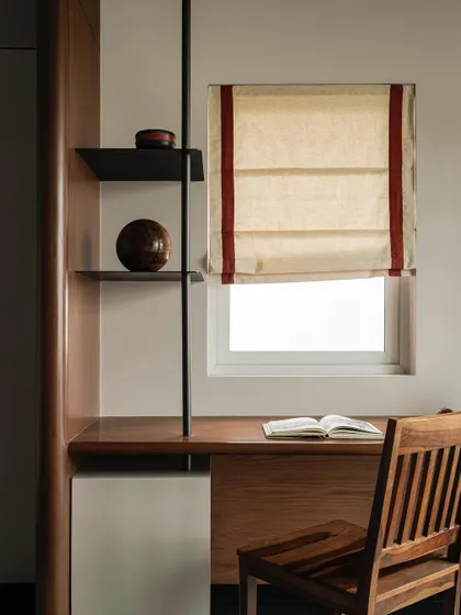 The study nook in a bedroom at Apartment 1005. We combined teak wood, steel supports, and simple fabric blinds to create a compact yet elegant space for work or reflection.