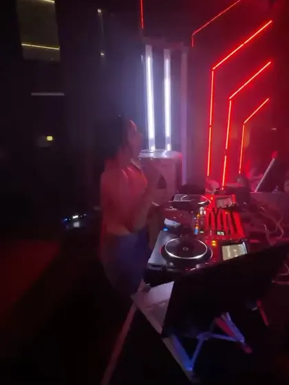 Bathed in the red glow of the club lights, I'm deep into a set. The atmosphere of a venue is a huge part of the night, and I love playing in well-designed spaces.