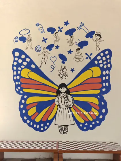 This butterfly mural features simple, cheerful wings and doodles above that depict children in various positive activities.