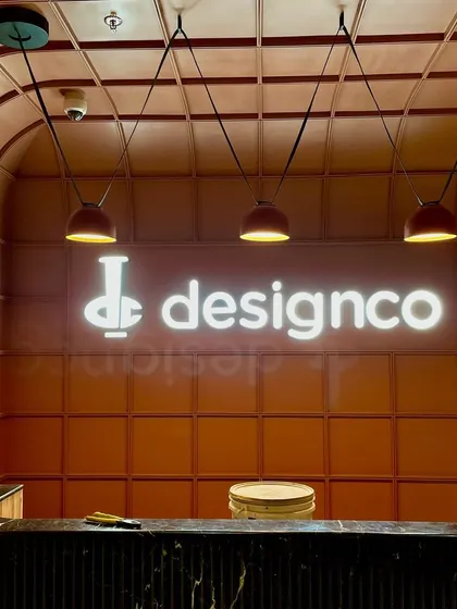 For the DesignCo office, we used lighting to reinforce their brand identity. The backlit signage creates a bold focal point at the reception, while suspended pendants provide functional, warm light over the desk, making the entrance both impressive and welcoming.