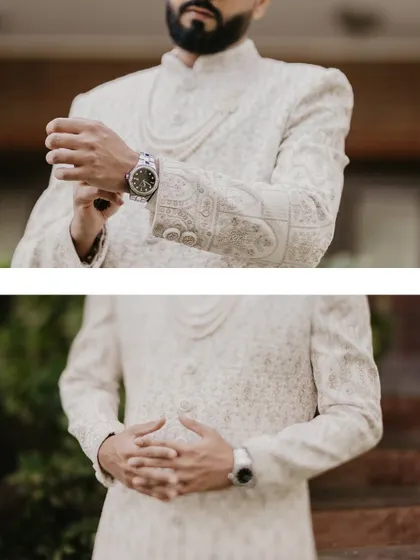 A detailed shot focusing on the groom's hands as he adjusts his sherwani, highlighting the details of his attire and watch.