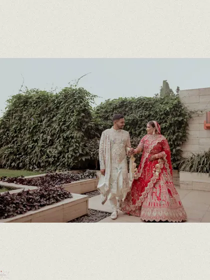 A beautiful shot of the couple walking together in a garden setting.