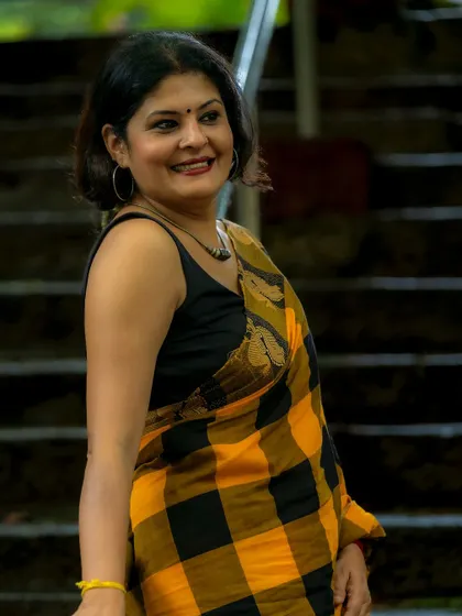 A candid, smiling portrait that shows the effortless charm of a well-draped cotton saree. It's a perfect example of comfortable yet stylish daywear.