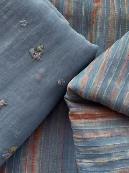 This set of Mul Chanderi fabrics includes a grey embroidered buti design and a coordinating striped fabric, perfect for creating a complete outfit.