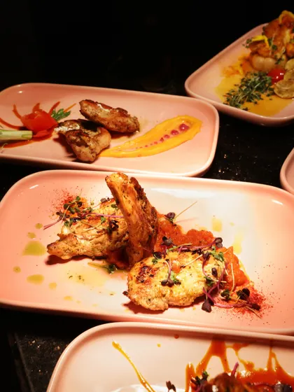 A dynamic plating of our Pan-Asian grilled chicken, with a creative smear of yellow sauce and carefully placed garnishes. The presentation is designed to be as exciting as the flavours.