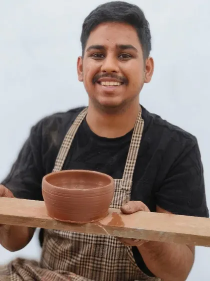 A student proudly holds up his first-ever wheel-thrown bowl. Our instructors provide step-by-step guidance to ensure that even beginners can create a well-shaped piece in their first session.