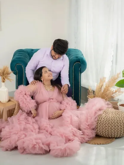 A sweet, interactive moment between an expecting couple in my lifestyle studio. He leans over the chair to talk to her, creating a candid and loving scene.