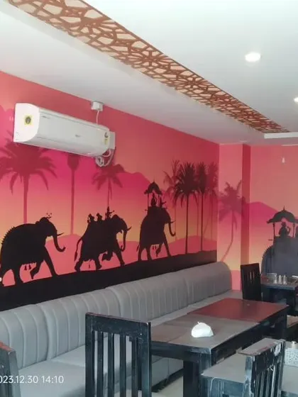 A custom mural for a restaurant, featuring a silhouette of a royal procession of elephants against a sunset.