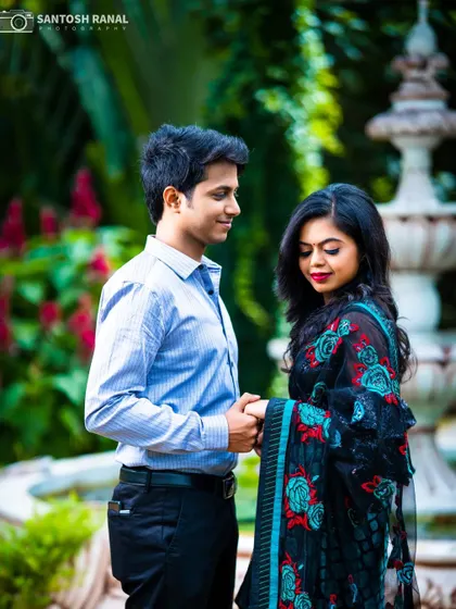A sweet and simple pre-wedding portrait of a couple holding hands in a garden.