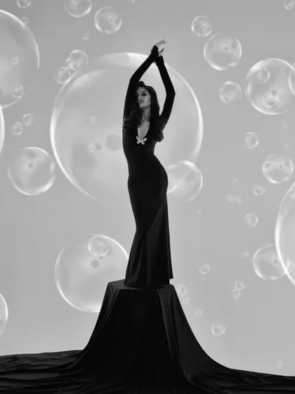 A graceful and elegant full-length pose in black and white. The bubbles create a magical atmosphere around the model.