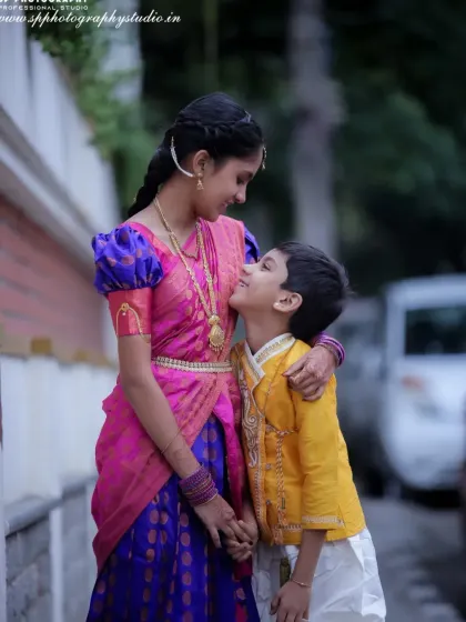 This heartwarming photo captures a sweet, candid moment between a brother and sister in their traditional outfits, highlighting their sibling bond.