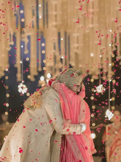 A heartfelt hug between the bride and groom after their Varmala, a candid moment of pure emotion and love.
