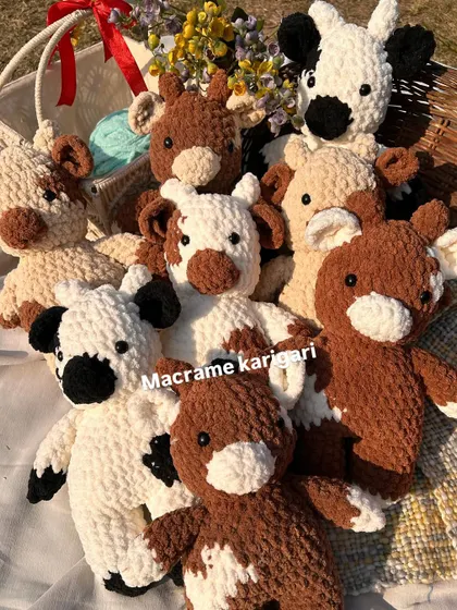 A whole herd of our chunky yarn crochet cows! We offer them in different color patterns like classic black and white, brown and white, and even pink. Each one comes with a little floral crown for extra cuteness.