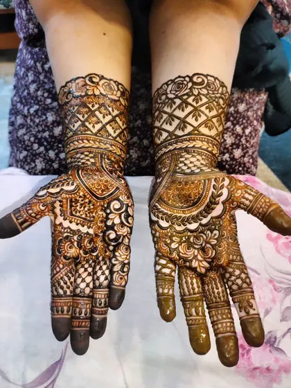 This design features beautiful checkerboard patterns on the wrists, complemented by intricate floral and paisley work on the hands.