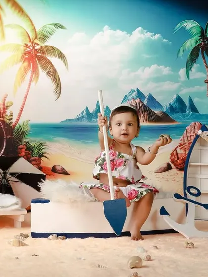Our little sailor girl is one! This beach-themed shoot includes fun props like a toy boat and anchor to create a complete seaside adventure.