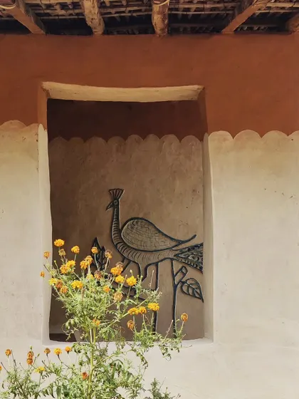 A close-up of a wall niche adorned with a peacock mural, a common motif in local folk art. These details, painted by the women of the family, transform a simple wall into a canvas for storytelling.