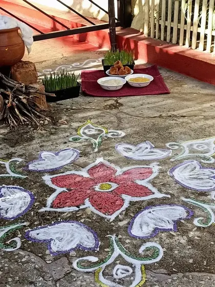 A beautiful rangoli and a traditional Pongal pot setup with firewood, ready for our celebration.