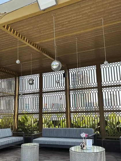 Disco balls hanging from the ceiling of this outdoor lounge area, ready for a party.