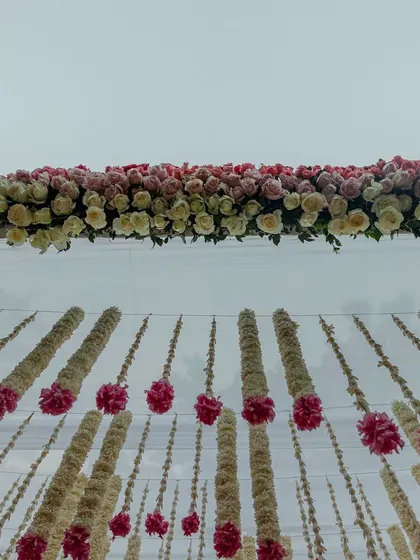 A ceiling of hanging tuberose and pink rose garlands.