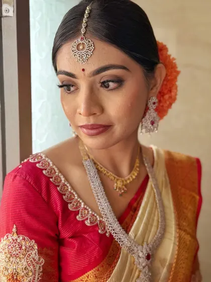 A pensive moment captured by the window. The natural light beautifully highlights the soft glam makeup, from the defined eyes to the subtle contouring, creating a timeless bridal portrait.