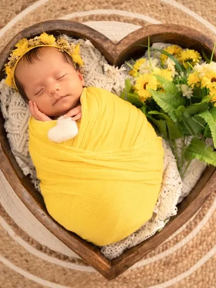 An overhead view of the sunflower theme, with the baby nestled in a heart-shaped bowl, surrounded by bright yellow flowers.
