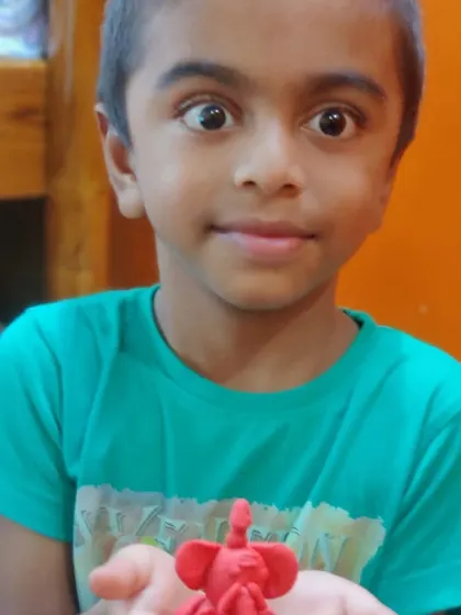 The intense look on this child's face shows his pride and excitement in sharing his creation.