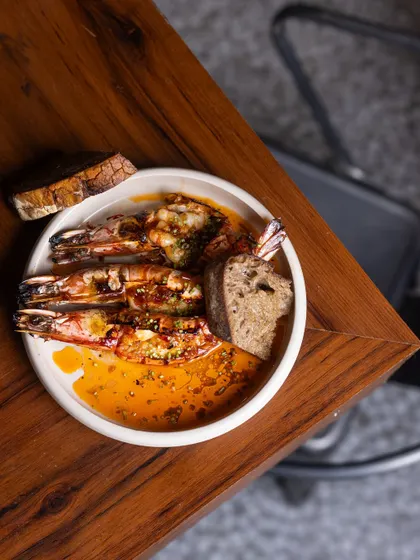When the flames kiss the prawns and the butter starts to sizzle, magic happens. My King Prawns are slow-cooked with garlic butter and a hint of fermented chili, served with warm sourdough for dipping.