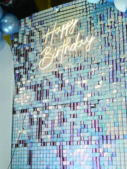 The iridescent shimmer wall was a fantastic backdrop for the cake cutting. The "Happy Birthday" neon sign adds a modern and celebratory touch to the car-themed decor.