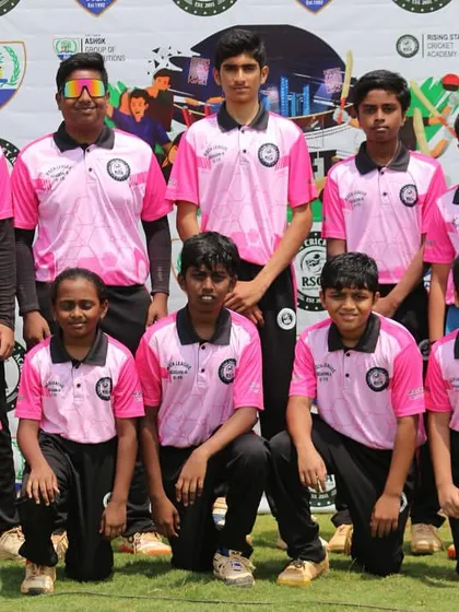 A team in pink jerseys poses for a photo in front of the RSCA League backdrop.