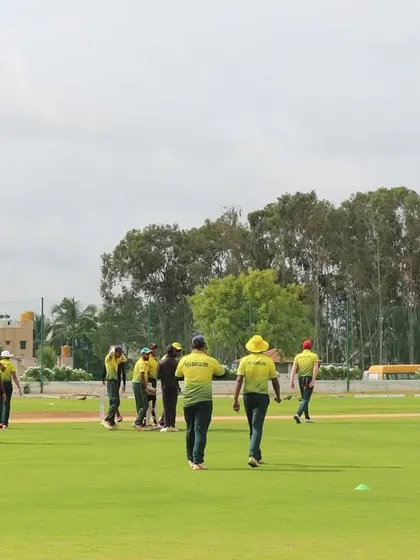 A team strategizes between overs on the field, showcasing the serious level of competition in our open-age tournaments.