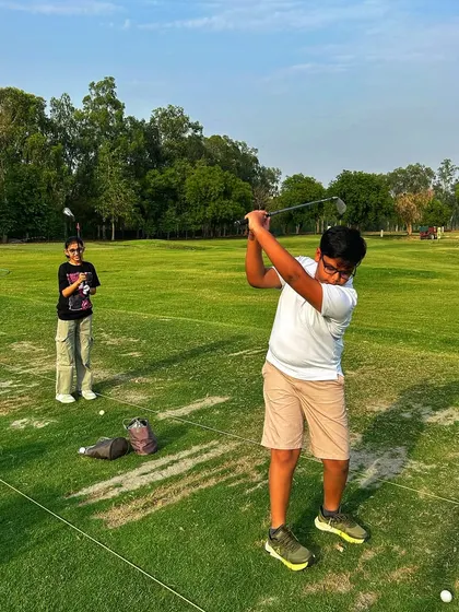 A young golfer shows off his follow-through while his friend looks on. We're passionate about nurturing the next generation of golfers.