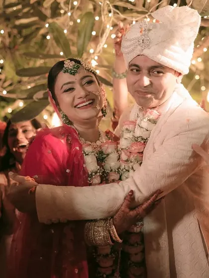 A big, happy hug between the newly married couple, surrounded by their loved ones.