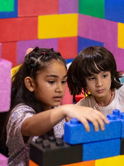 Siblings working together to create a masterpiece with our giant building blocks. It's a fantastic activity for fostering creativity and cooperation.