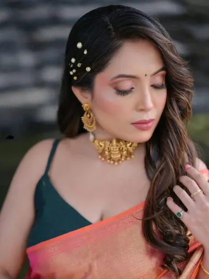 A close-up of a model's look, showing the soft waves and pearl pin details in her hair.