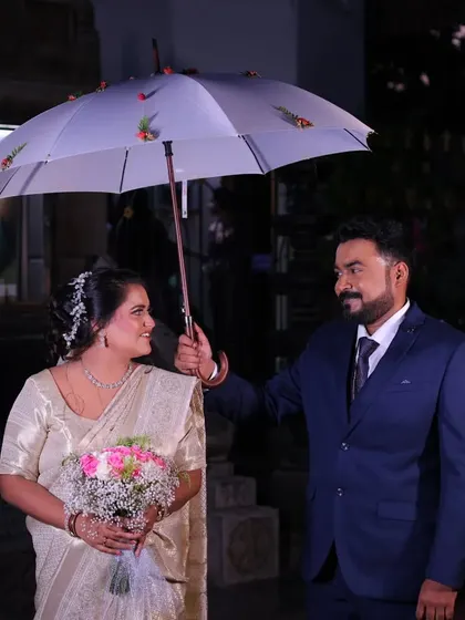 A sweet moment from a Christian wedding, with the groom holding an umbrella for his bride. I plan weddings across all cultures with equal care.