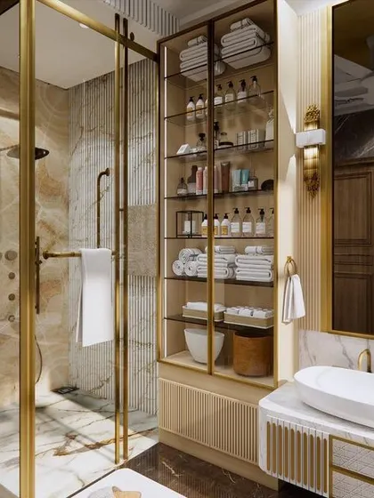 A master washroom designed for a high-end residence, featuring a luxurious walk-in shower with gold-finished fixtures and beautiful onyx-style tiles. The design creates a spa-like experience at home.