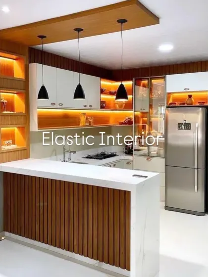 This kitchen combines white cabinets with wood accents and a striking breakfast counter. The open shelves with warm backlighting are perfect for displaying decor items.