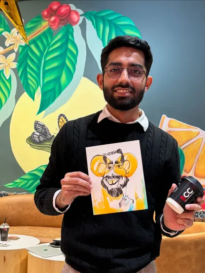 A happy customer with his coffee and his caricature at The Black Coffee Cafe.